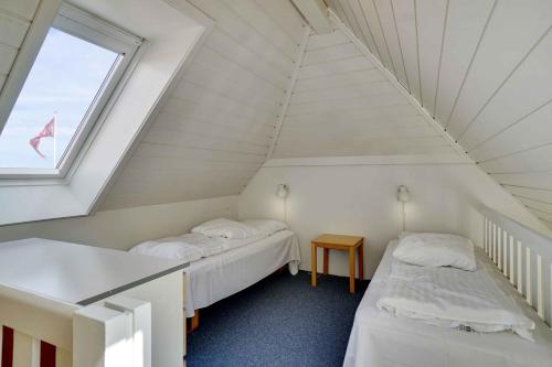 Dos camas en una habitación con ventana. en Unique Holiday Apartment With A View In Skagen, en Skagen