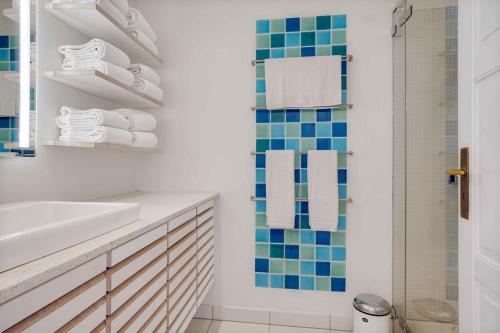 y baño con lavabo y ducha con toallas. en Unique Holiday Apartment With A View In Skagen, en Skagen
