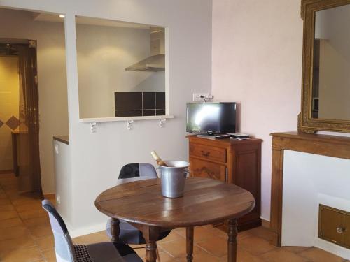 a room with a wooden table and a tv at Charmant Studio au Cœur de Pontlevoy avec Jardin, Parking et Ateliers Pâtisserie - FR-1-491-363 in Pontlevoy