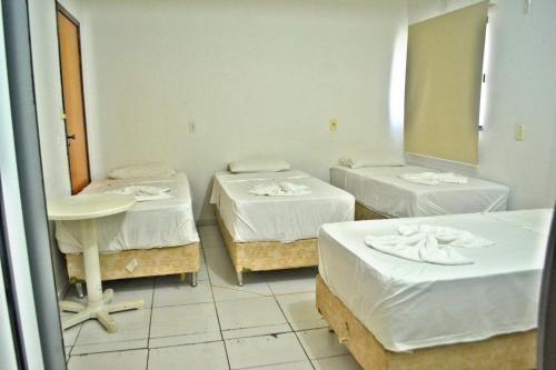 a room with two beds and a mirror at Hotel Jardim do Porto in Palmas