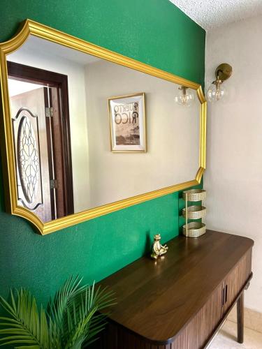 a mirror on a green wall with a wooden table at Tropical Oasis! 5BR Luxe Home in Dorado