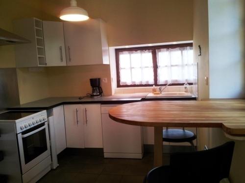 une cuisine avec une table, un évier et une fenêtre dans l'établissement Grande maison avec cheminée et jardin à Bressolles - FR-1-489-576, à Bressolles