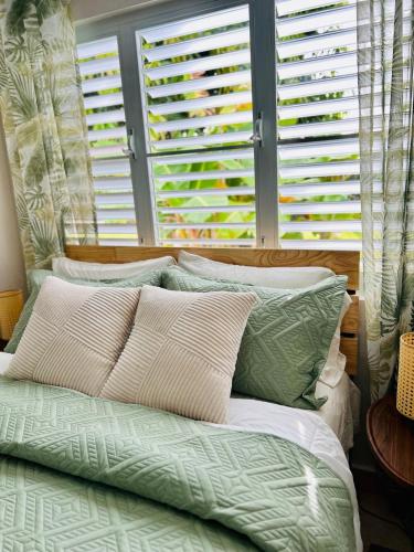 a bed with green and white pillows and a window at Tropical Oasis! 5BR Luxe Home in Dorado