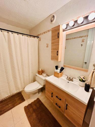 a bathroom with a toilet and a sink and a mirror at Tropical Oasis! 5BR Luxe Home in Dorado