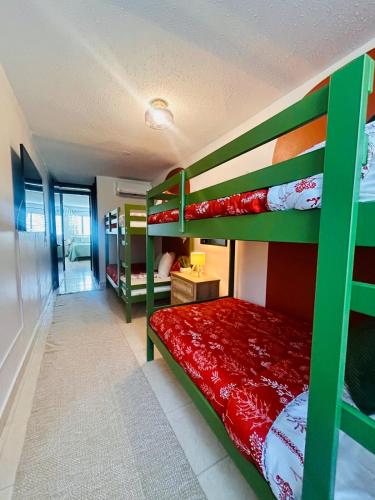 a bedroom with green bunk beds and a red bed at Tropical Oasis! 5BR Luxe Home in Dorado