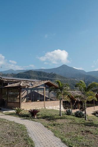 a building with palm trees in front of it at Idilicos Mauá in Visconde De Maua