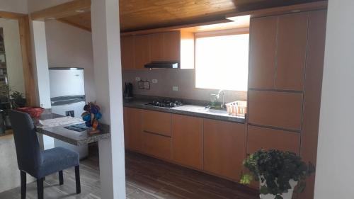 a kitchen with wooden cabinets and a table and a window at Refugio del Sauce Cabaña 1 Tibasosa- Boyacá in Tibasosa