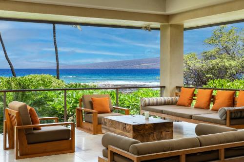 a living room with a view of the ocean at Hale Waima Lani in Puako