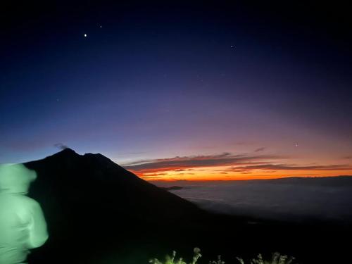 a view of a mountain with the sunset in the background at Ariel Bungalow Tetebatu in Tetebatu