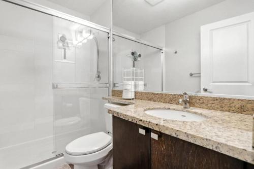 a bathroom with a toilet and a sink and a shower at 17th Avenue Paranomas Escape in Calgary