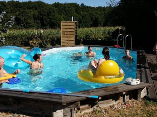 un groupe de personnes dans une piscine dans l'établissement Gîte indépendant avec piscine, proche forêt et étang, parking, tennis et minigolf - FR-1-489-139, à Isle-et-Bardais