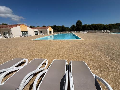 un groupe de chaises assises à côté d'une piscine dans l'établissement Maison calme avec piscine et proche plage à Talmont-Saint-Hilaire - FR-1-197-488, à Saint-Hilaire-de-Talmont