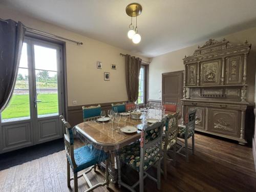 une salle à manger avec une table et des chaises et une fenêtre dans l'établissement Maison Bourgeoise de Charme avec Spa, Parc et Activités - FR-1-489-541, à Jaligny-sur-Besbre