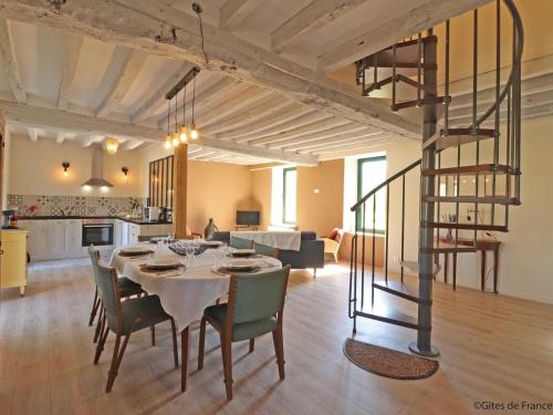 une salle à manger et un salon avec une table et des chaises dans l'établissement Maison en pierres avec Grand Jardin, WIFI, tout inclus - FR-1-497-170, à Neuvy-au-Houlme