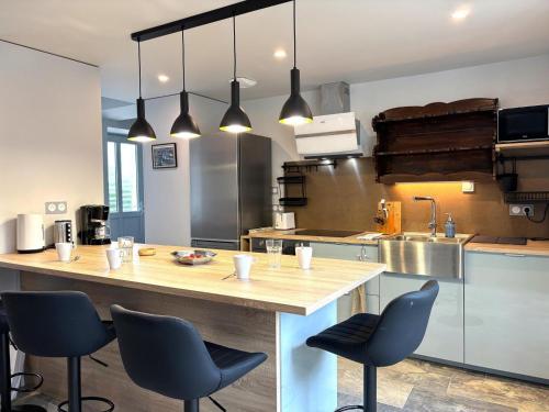 - une cuisine avec un comptoir et quelques chaises dans l'établissement Gîte Les 3 chats à Autry-Issards, Charme & Confort pour 8 pers. - FR-1-489-577, à Autry-Issards