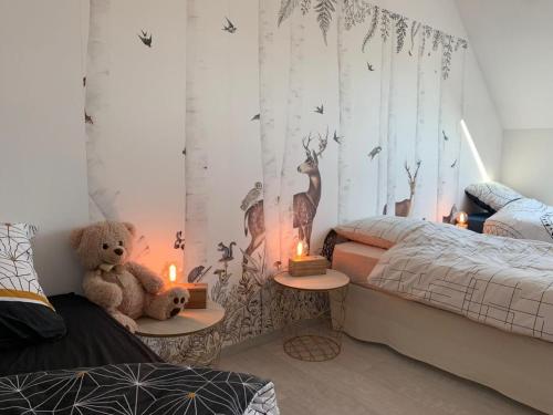 ein Schlafzimmer mit zwei Betten und einem Teddybär und Kerzen in der Unterkunft Maison rénovée en Sologne Bourbonnaise avec Jardin et WiFi - FR-1-489-379 in Saligny-sur-Roudon