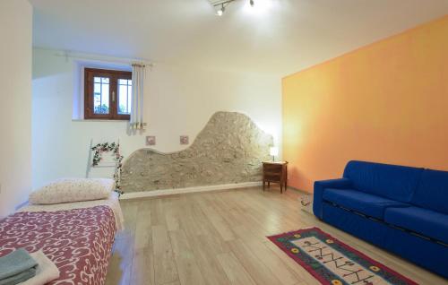 a living room with a blue couch and a stone wall at Gorgeous Apartment In Solferino in Solferino