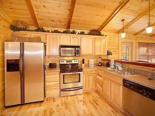 a kitchen with stainless steel appliances and wooden cabinets at Sweet Dreams Holiday home in Gatlinburg