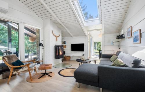 a living room with a couch and a tv at Nice Home In Blåvand With Wifi in Blåvand
