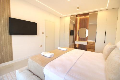 a bedroom with a large bed and a flat screen tv at Golden View Villa Sauna & Spa in Blagaj