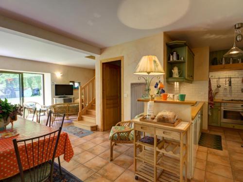 une cuisine et un salon avec une table et des chaises dans l'établissement Gîte familial en pierre avec jardin, près des chemins de randonnée et forêts, idéal détente et nature - FR-1-496-1, à Marols