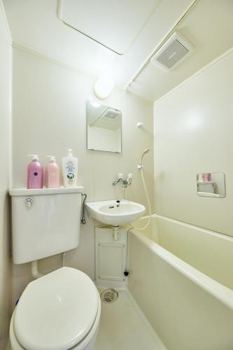 a white bathroom with a toilet and a sink at KYOTO R01 - 10 sec walk-Ryoanji Station in Kyoto