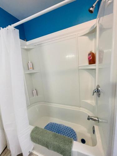 a bathroom with a white tub and a blue ceiling at Prime and Precious location The Red House Room3 in Charlottetown