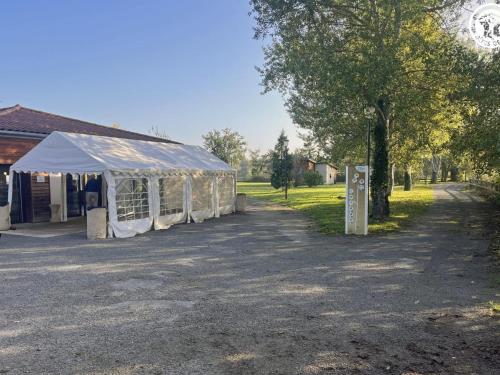 a tent is set up in front of a building at Chalets bord d'étang avec terrasse privée et équipements loisir, parfaits pour une escapade nature - FR-1-496-79 in Veauchette