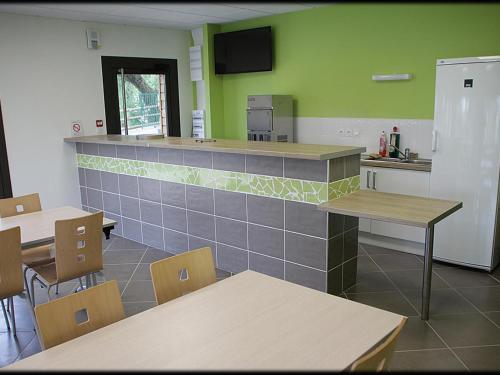 a kitchen with tables and a counter in a room at Chalets bord d'étang avec terrasse privée et équipements loisir, parfaits pour une escapade nature - FR-1-496-79 in Veauchette