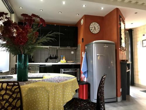 a kitchen with a table and a refrigerator at Gîte de charme avec terrasse, Wi-Fi et équipement bébé - FR-1-496-125 in Chagnon