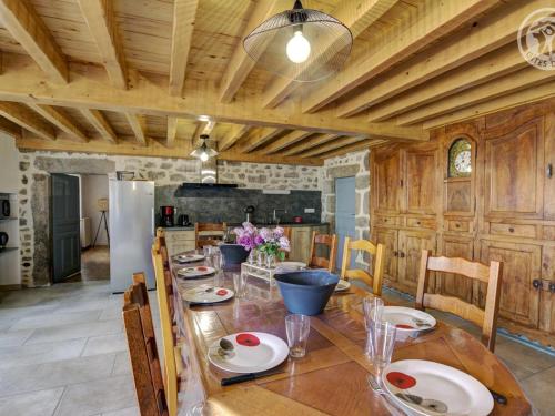 une salle à manger avec une grande table et une cuisine dans l'établissement Gîte de charme avec jardin et wifi à Chalmazel-Jeansagnière - FR-1-496-249, à Chalmazel Jeansagniere