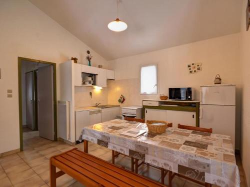 Il comprend une cuisine équipée d'une table et d'un réfrigérateur. dans l'établissement Gîte avec Cheminée, Terrasse et WiFi - Animaux Acceptés - FR-1-496-163, à Usson-en-Forez