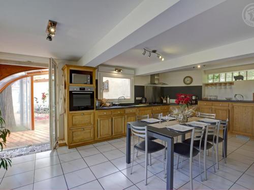 a kitchen with a table and some chairs in it at Gîte de charme avec spa, sauna et jardin privatif à Montbrison - FR-1-496-309 in Montbrison