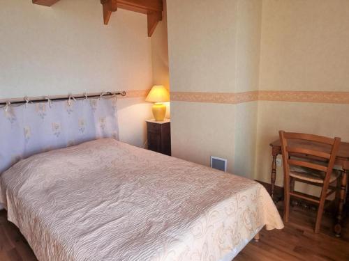 ein Schlafzimmer mit einem Bett, einem Tisch und einem Stuhl in der Unterkunft Ancienne ferme restaurée avec piscine privée et cheminée - FR-1-496-328 in Saint-Sixte