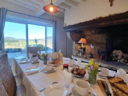 une salle à manger avec une table et une cheminée dans l'établissement Gîte familial spacieux, 14 pers, charme et confort - FR-1-496-349, à Saint-Jean-la-Vêtre