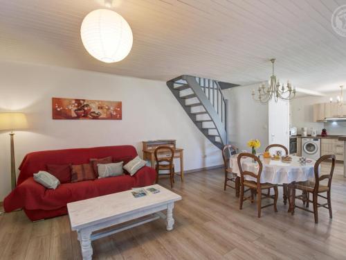 un salon avec un canapé rouge et une table dans l'établissement Charmant Gîte Rénové avec Jardin Privatif, Wifi inclus - FR-1-496-331, à Marlhes