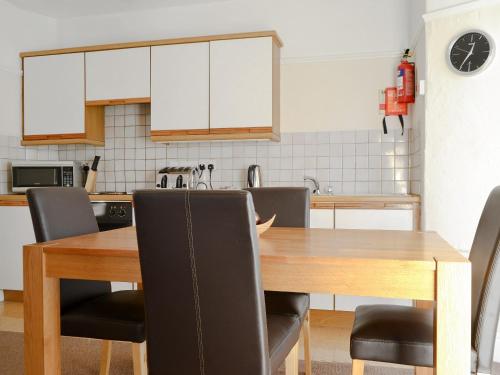 a kitchen with a wooden dining table and chairs at Cat Bells in Keswick