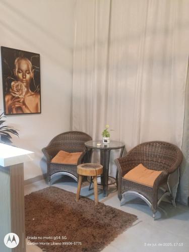 a living room with three chairs and a table at Flat no Garden I in Rondonópolis
