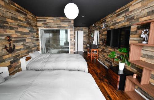 a bedroom with two beds and a tv at MARINE-Q in Inami