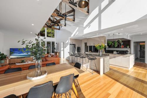 a kitchen and living room with a wooden table and chairs at La Dolce Vita in Port Fairy