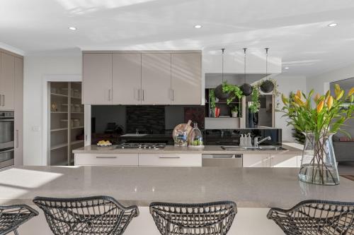 a kitchen with white cabinets and a table with chairs at La Dolce Vita in Port Fairy