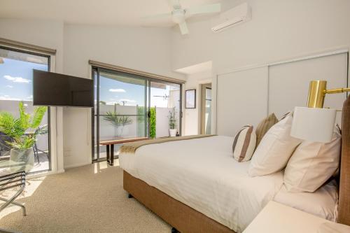 a bedroom with a bed and a large window at Luxe Townhouse on the Paynesville Waterfront Esplanade in Paynesville