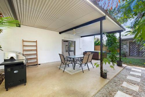 un patio con tavolo, sedie e griglia di Casuarina Cove - Foreshore Tropical Escape near CBD a Nightcliff