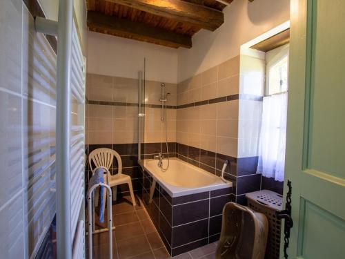 une salle de bain avec une baignoire, une table et une chaise dans l'établissement Maison périgourdine avec piscine et jardin à Saint-Avit-Sénieur - FR-1-616-104, à Saint-Avit-Sénieur