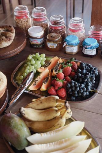 a table topped with plates of fruit and vegetables at Idilicos Mauá in Visconde De Maua