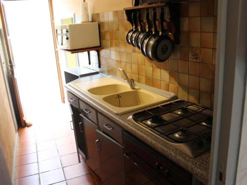 Il comprend une cuisine équipée d'un évier et d'une cuisinière. dans l'établissement Maison périgourdine avec jardin privé, cheminée, animaux acceptés - FR-1-616-388, à Saint-Marcel-du-Périgord