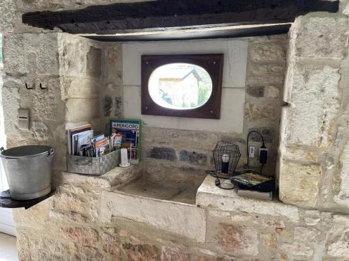 a stone wall with a window and books on it at Maison spacieuse avec jardin à Jayac, 3 chambres - FR-1-616-465 in Jayac