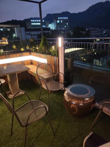 a patio with a table and chairs on a roof at Kiman09 in Seoul