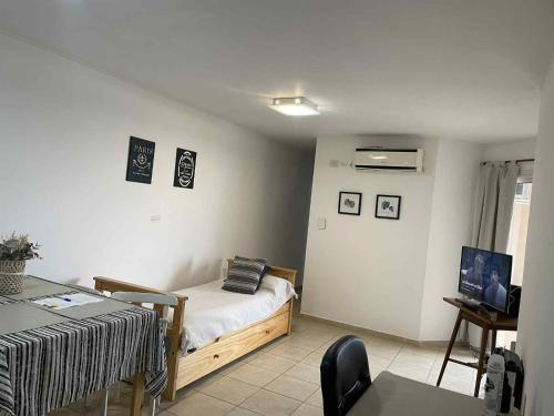 een slaapkamer met een bed, een tafel en een bureau bij Departamento Vista Bella, céntrico y cercano a la terminal, Exc ubicación, playa estacionamiento cercana-económica in Villa María