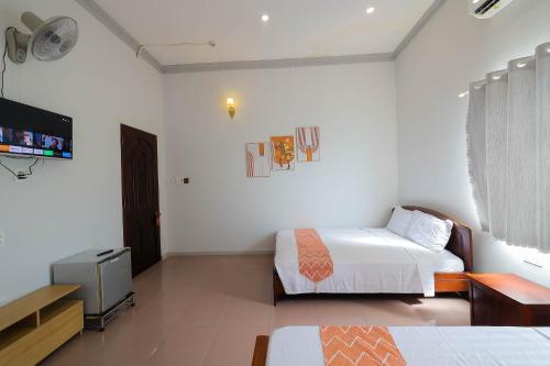 a bedroom with two beds and a flat screen tv at Happy Bear Hostel Phu Quoc in Phu Quoc